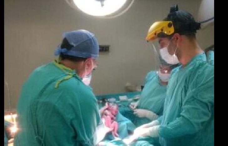 el obstetra, Marcelo rey, de espaldas durante la cesárea.