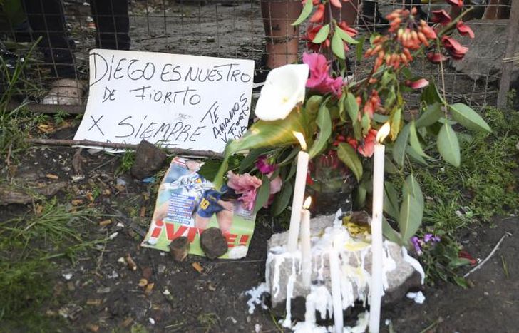 Velas, flores, carteles y banderas, frente a la casa de Fiorito.