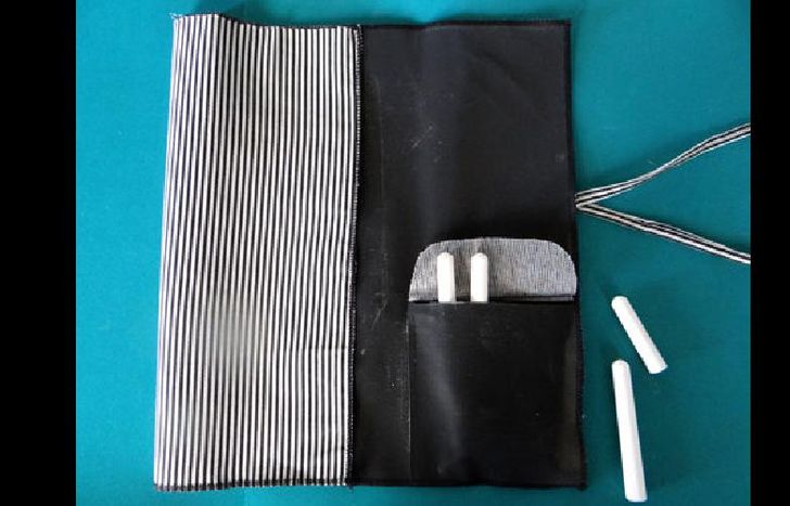 4. Colocar las tizas en el bolsillo. Doblar la pieza en 4 y atar con los lazos para cerrar. Luego de utilizarla, limpiar lo escrito con un paño húmedo.