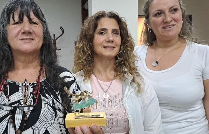 Feliz recibiendo su premio junto a las autoridades del Banco Credicoop.