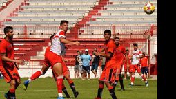 Fabricio Lenci, autor de un gol, gana en las alturas sobre el área defendida por Martín Ríos.