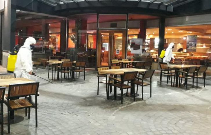 Desinfectan las mesas y sillas de cada local.