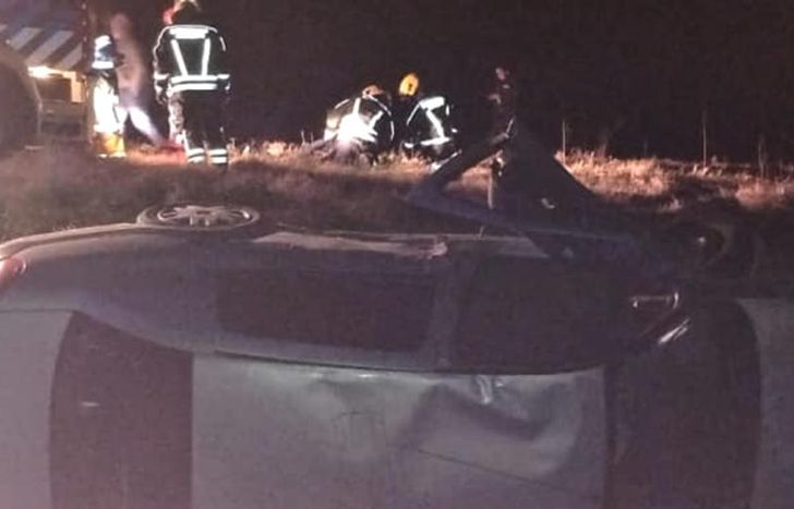 El auto volcado y detrás, el operativo de asistencia.