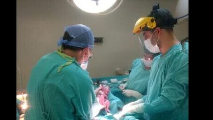 el obstetra, Marcelo rey, de espaldas durante la cesárea.