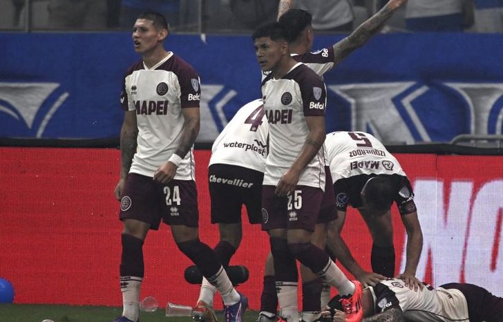 Carrera, en el piso, festeja su gol con sus compañeros.
