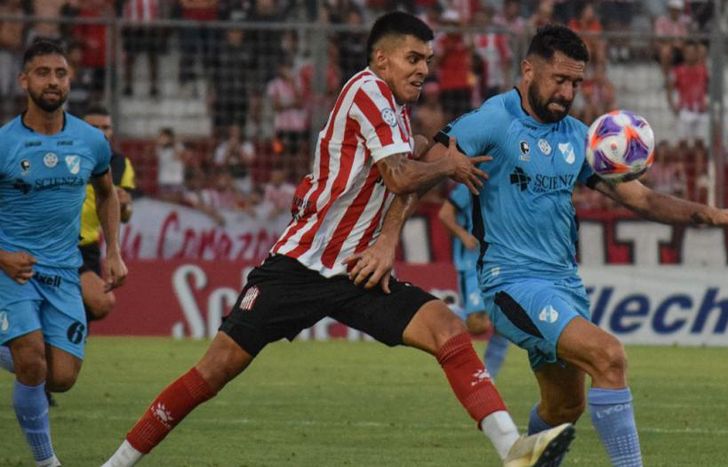 Alan Pérez cubre la pelota ante un rival.