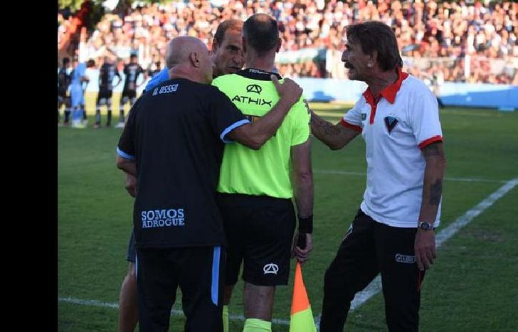 Pablo Vico y el Bocha Scalenghe dialogan con el asistente Mariano Altavista sobre la jugada del penal para Temperley.
