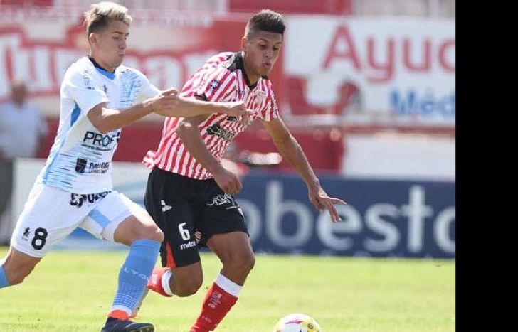 Sebastián Valdez se lleva la pelota frente a Tobías Reinhart. El defensor fue la figura del clásico.