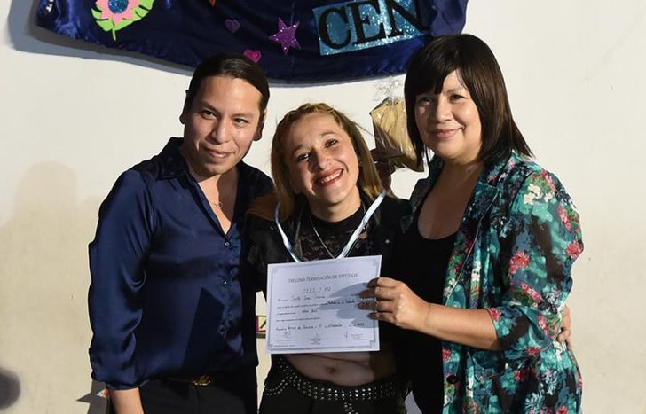 Dos de sus profesores le entregaron el diploma.