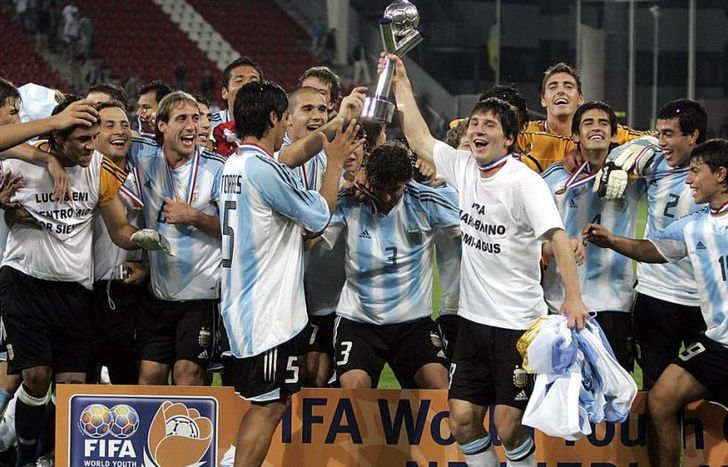 Messi alza la copa, con todos sus compañeros alrededor.