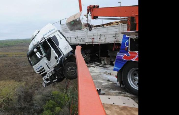 Entre Ríos: Un camión cargado con bobinas de hilo chocó contra la defensa y su cabina quedó colgado del puente Zárate-Brazo Largo, a la altura del kilómetro 111 de la ruta nacional 12 en jurisdicción de la provincia de Entre Ríos, tras perder el control y embestir la defensa lateral, aunque su conductor resultó ileso. Foto: José Romero