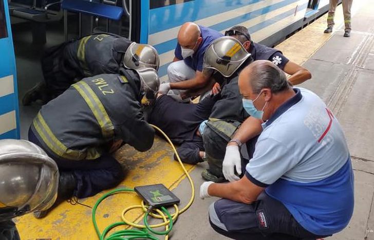 Los bomberos intentando liberar al hombre con cuidado.