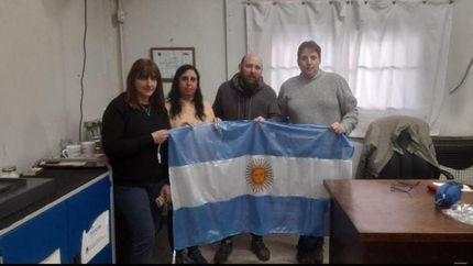 José, junto a los directivos de la escuela. La bandera, lista para flamear.