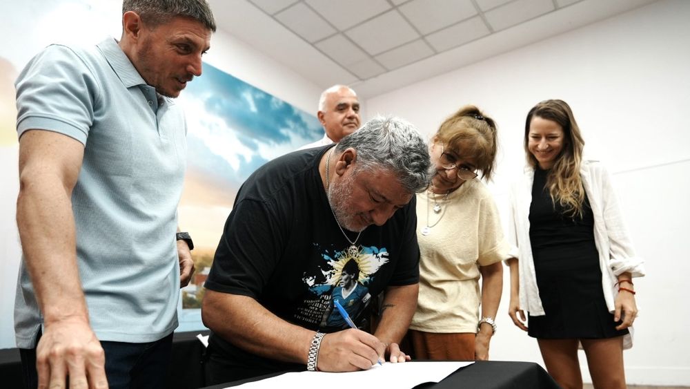 Juan Carlos Peralta, veterano de Malvinas, firmando el convenio de escrituración junto a su esposa.