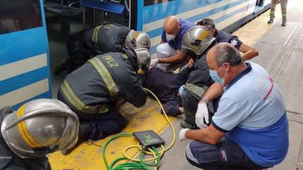 Los bomberos intentando liberar al hombre con cuidado.