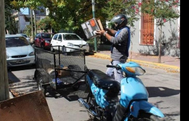 Los motorrecicladores retiran las bolsas de los domicilios.