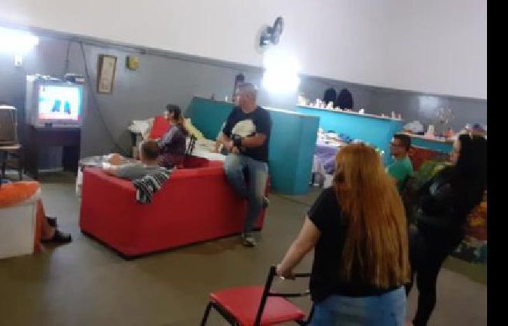 Las personas de Casa de Encuentro ayer mirando la noticia de la cuarentena obligatoria.