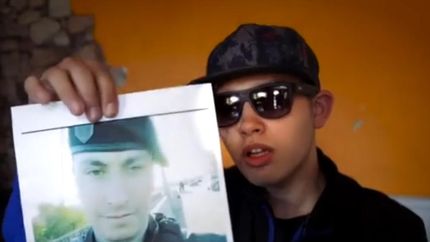 Ignacio Seijas sostiene la foto del policía que le disparó.