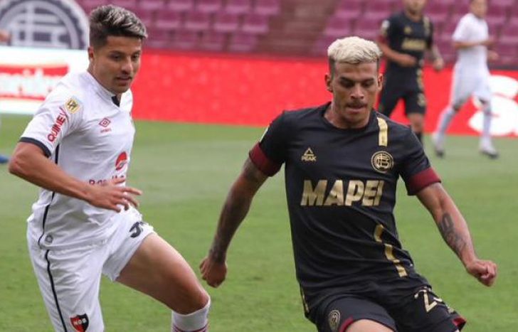 Vera intenta llevarse la pelota ante la mirada de Palacios.