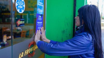 Pusieron stickers informativos en comercios de diferentes rubros.