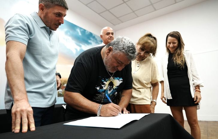 Juan Carlos Peralta, veterano de Malvinas, firmando el convenio de escrituración junto a su esposa.