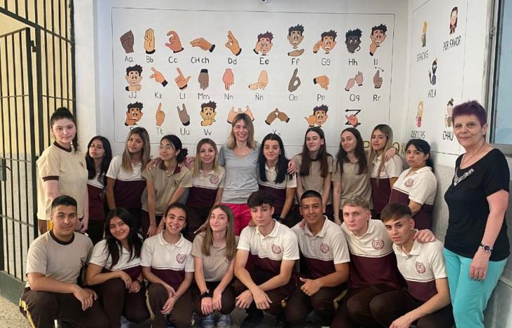 Alumnos, la docente Jesica (centro) y la directora Mónica Urquiza (derecha) junto al mural.