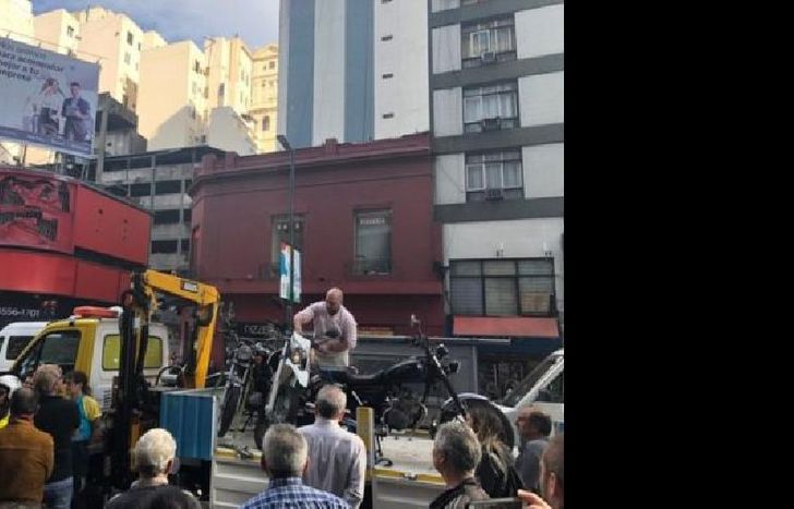 El momento en el que el hombre subió arriba de la grúa y bajó la moto.