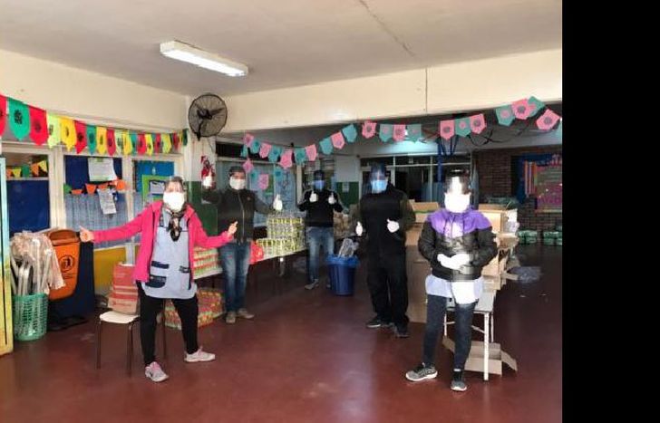 los docentes del jardín con las máscaras confeccionadas por los alumnos de Lomas.