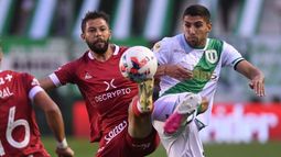 Álvarez y Grimi se disputan la posesión de la pelota.