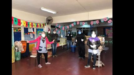 los docentes del jardín con las máscaras confeccionadas por los alumnos de Lomas.