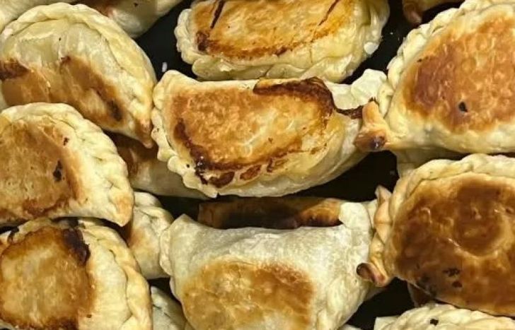 Preparan empanadas para llevar a las personas en situación de calle.