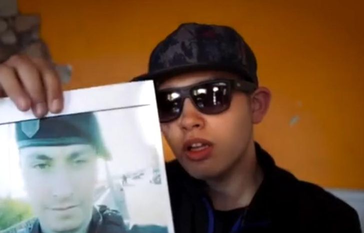 Ignacio Seijas sostiene la foto del policía que le disparó.