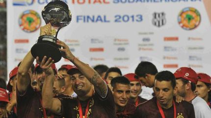 Somoza y Silva levantan el trofeo conseguido en 2013.