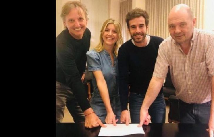 Los protagonistas junto a los productores con el contrato.