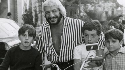 El actor es el que tiene una prenda oscura.