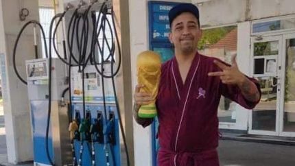Cristian en bata con la Copa del Mundo en una YPF de Temperley.