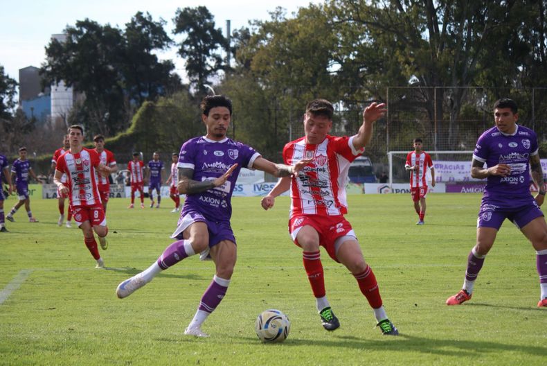 Mateo Del Pino cruza para salvar el arco de Talleres de Escalada.