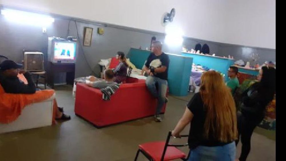 Las personas de Casa de Encuentro ayer mirando la noticia de la cuarentena obligatoria.