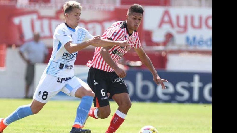 Sebastián Valdez se lleva la pelota frente a Tobías Reinhart. El defensor fue la figura del clásico.